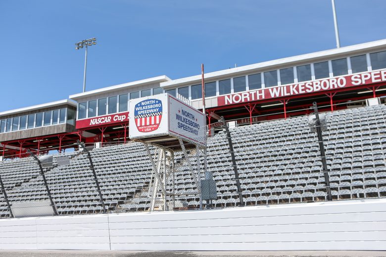 North Wilkesboro Speedway grandstand view with a sign, clear blue sky